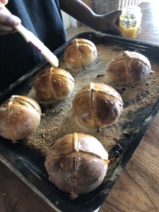 Then, after the final kneed, and before the final rise, divide your dough into buns. ( A dough based on 500 g of flour will make 12 buns). Rise the buns on a well-floured board (or two) for about 60-75 mins, until almost doubled in size. Then add the crosses, made from a simple flour and water paste, either sift enough to pipe, or firm enough to roll and cut into strips. Brush the buns and crosses with an egg beaten with a dash of milk. Carefully transfer the buns to an oiled, floured (or parchment covered) baking sheet (or two).